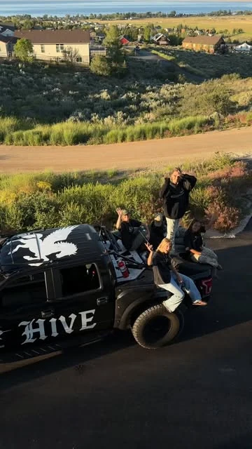 HIVE’s crew sitting together on a black truck