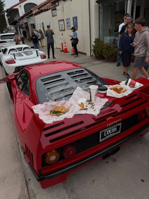 Friends stopping for food beside the HIVE Ferrari F40 and Carrera GT